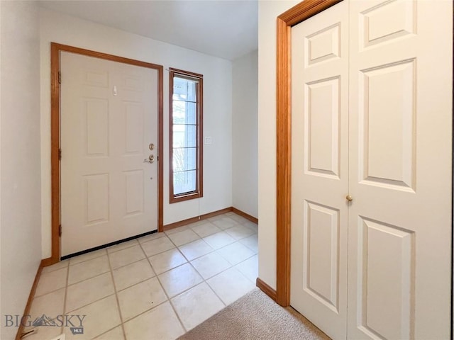 foyer featuring light tile patterned flooring and baseboards