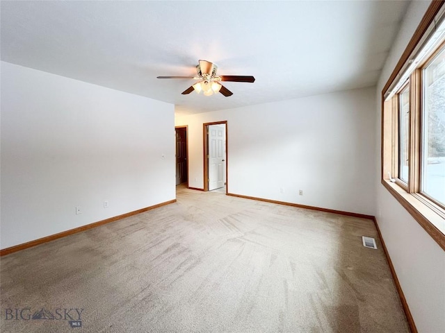 spare room featuring visible vents, baseboards, and ceiling fan