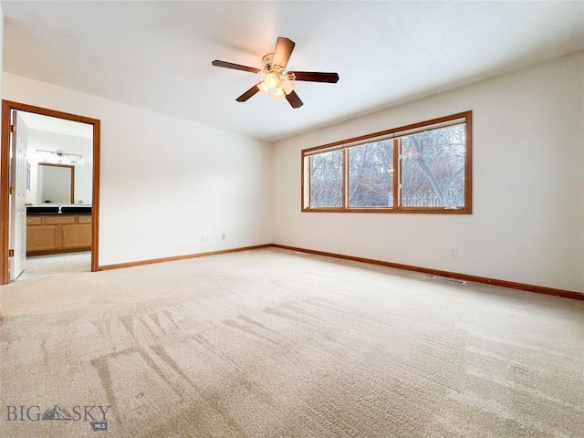 empty room featuring ceiling fan, baseboards, visible vents, and light carpet