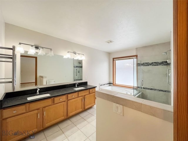 full bath featuring a sink, a garden tub, a shower stall, and tile patterned floors