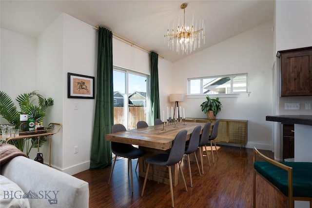 dining space featuring baseboards, a notable chandelier, dark wood finished floors, and vaulted ceiling