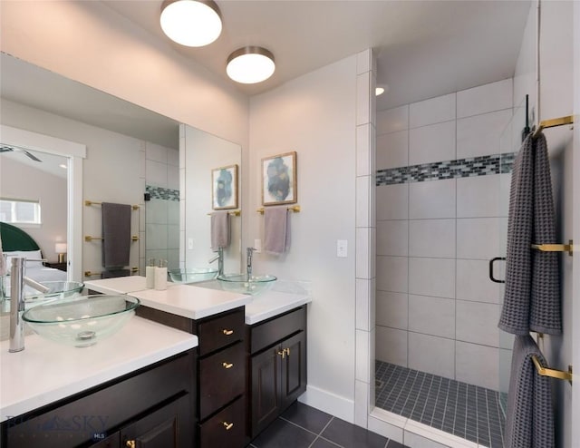 bathroom featuring tile patterned floors, two vanities, a stall shower, and a sink