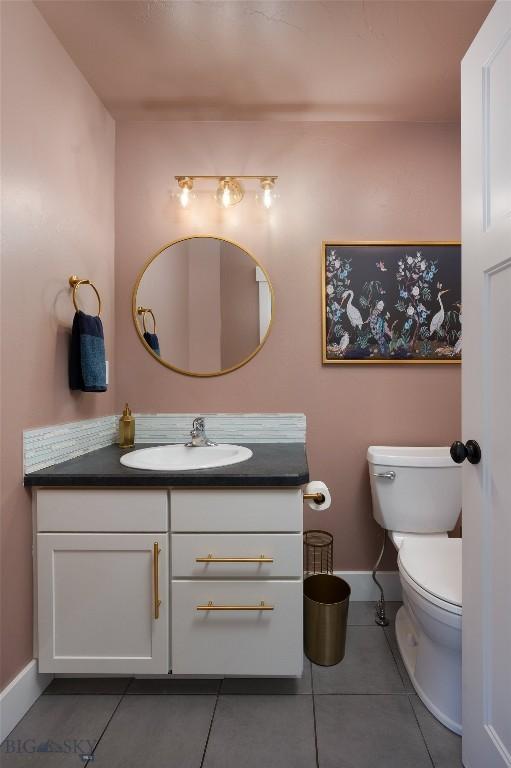 bathroom featuring tile patterned floors, toilet, vanity, and baseboards