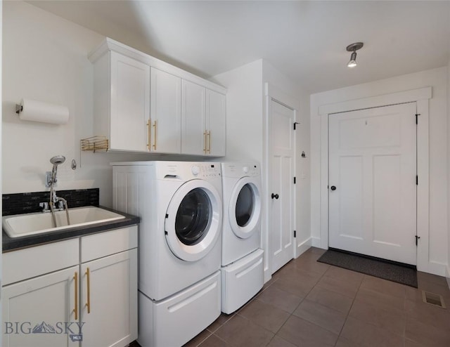 laundry room featuring visible vents, a sink, dark tile patterned floors, cabinet space, and separate washer and dryer