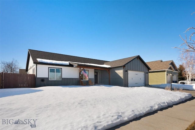 view of front of home featuring board and batten siding, an attached garage, and fence