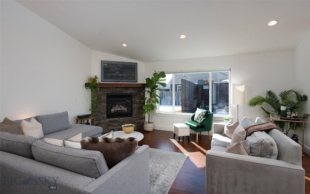 living area featuring baseboards, lofted ceiling, a stone fireplace, recessed lighting, and dark wood-style floors