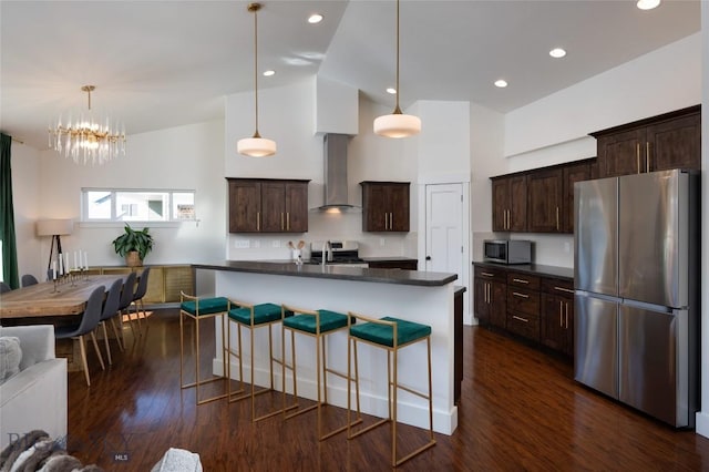 kitchen featuring a sink, dark countertops, stainless steel appliances, wall chimney range hood, and dark brown cabinets