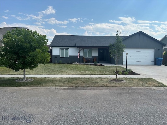 ranch-style home with board and batten siding, a front lawn, a garage, and driveway