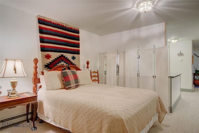 carpeted bedroom featuring a baseboard radiator and baseboards