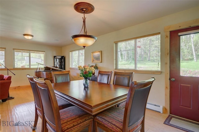 dining area featuring baseboards, light wood-style floors, and a baseboard radiator