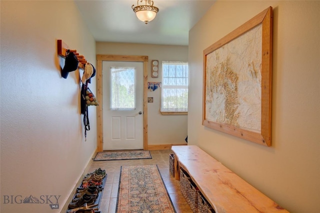 doorway to outside with tile patterned floors and baseboards