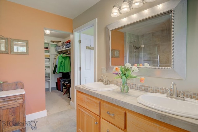 full bath featuring double vanity, a stall shower, a spacious closet, and a sink