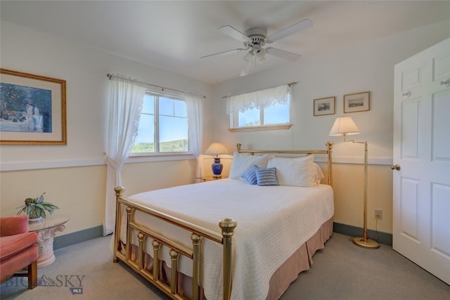 bedroom featuring light colored carpet, baseboards, and ceiling fan