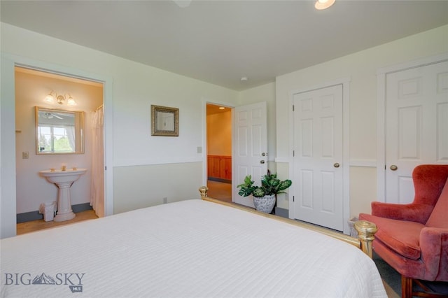 bedroom featuring connected bathroom and wood finished floors