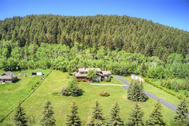 birds eye view of property featuring a forest view