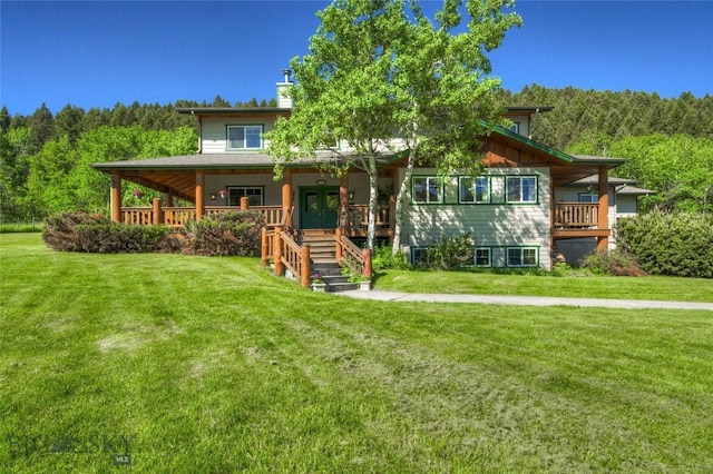 view of front of property featuring a forest view, covered porch, and a front yard