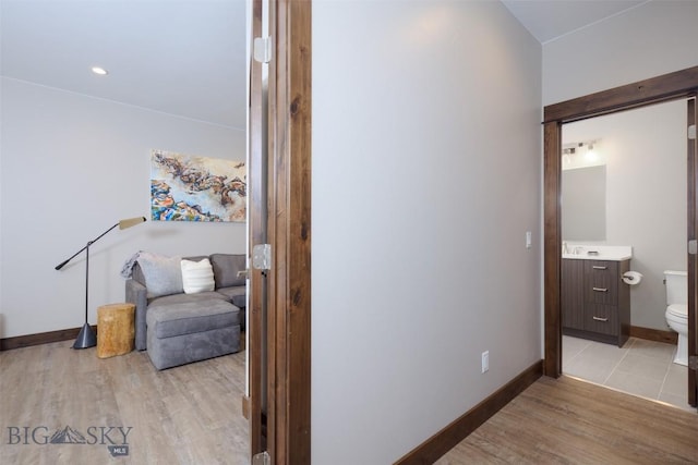 hallway featuring baseboards and light wood-style floors