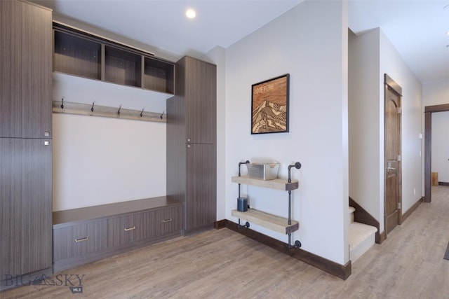 mudroom featuring light wood finished floors and baseboards