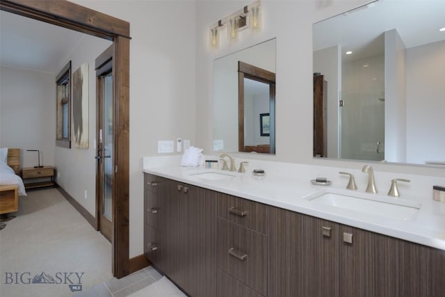 bathroom featuring double vanity, connected bathroom, a shower stall, and a sink