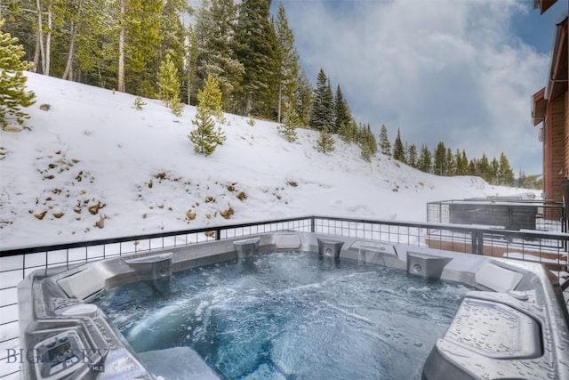 snow covered deck with a hot tub