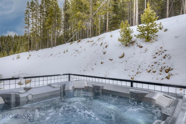 exterior space featuring a forest view and a hot tub