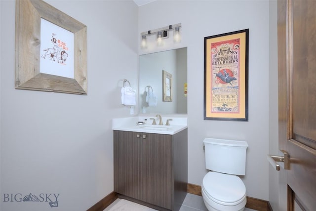 bathroom with toilet, vanity, and baseboards