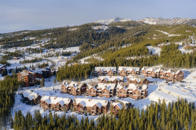 snowy aerial view with a mountain view and a residential view