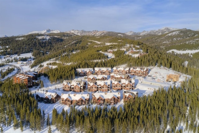 snowy aerial view with a mountain view and a residential view