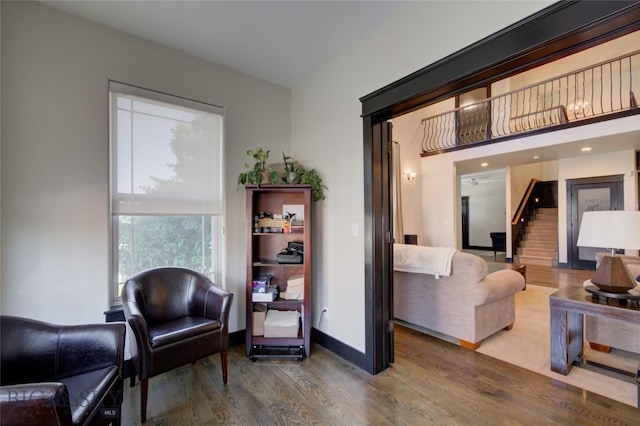 sitting room featuring stairway, baseboards, and wood finished floors