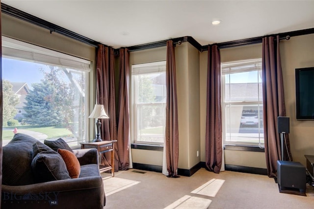 sitting room with baseboards, light carpet, and visible vents