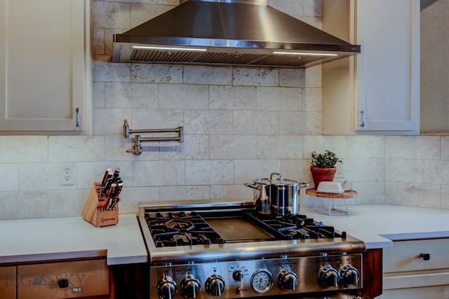 kitchen featuring tasteful backsplash, stove, range hood, and light countertops