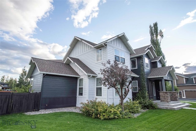 craftsman house featuring a front yard, fence, board and batten siding, and roof with shingles