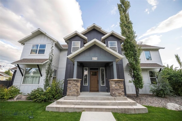 craftsman-style home featuring board and batten siding, a shingled roof, and a front yard