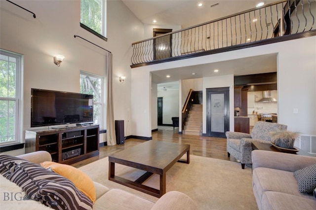 living room with stairs, plenty of natural light, wood finished floors, and visible vents