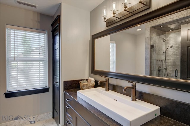 full bath featuring vanity, a shower stall, and visible vents