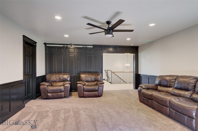 living area with recessed lighting, light carpet, ceiling fan, and wainscoting