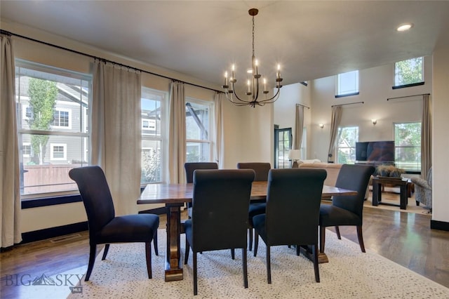 dining room with visible vents, plenty of natural light, an inviting chandelier, and wood finished floors