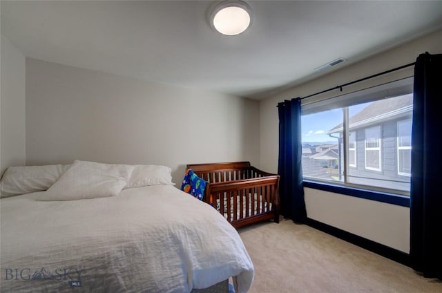 bedroom with visible vents and light carpet