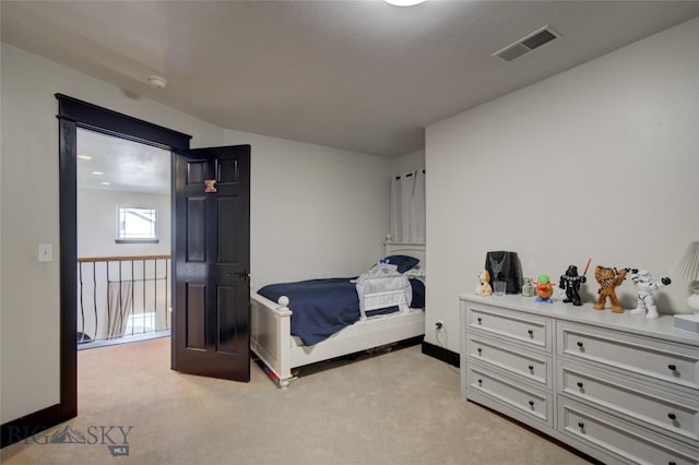 bedroom featuring baseboards, visible vents, and light carpet