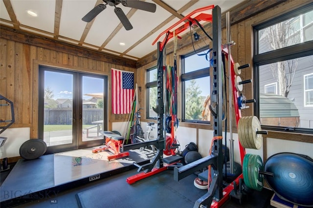 workout room with french doors, wooden walls, and ceiling fan