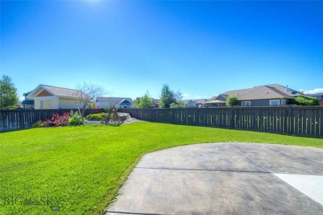 view of yard with a residential view, a fenced backyard, and a patio area