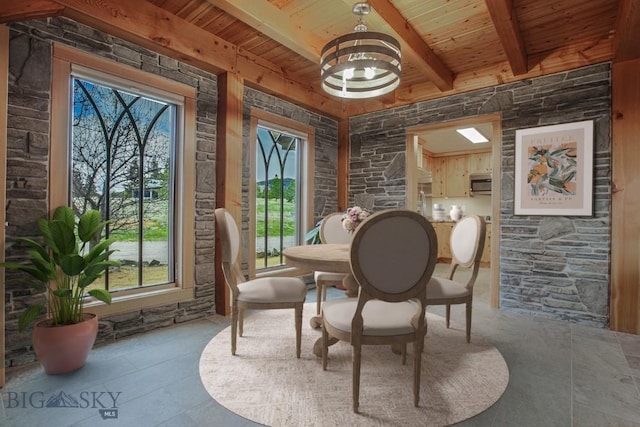 dining space featuring beamed ceiling, a notable chandelier, and wood ceiling