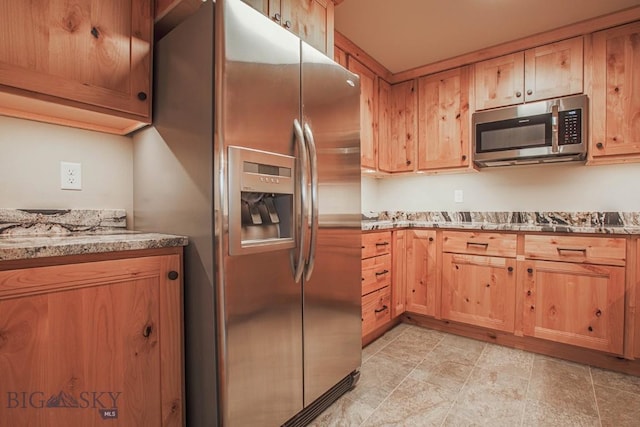 kitchen featuring light stone counters and stainless steel appliances