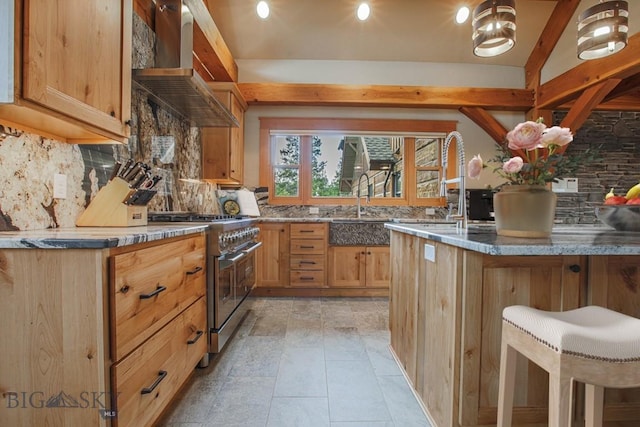 kitchen with light stone counters, backsplash, wall chimney exhaust hood, and high end stainless steel range oven