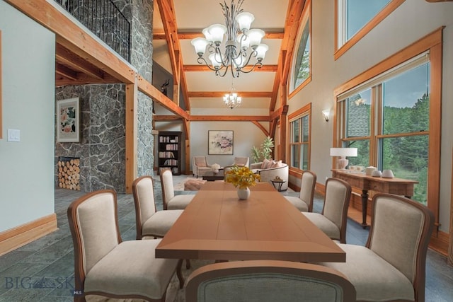 dining space with baseboards, a towering ceiling, and a chandelier