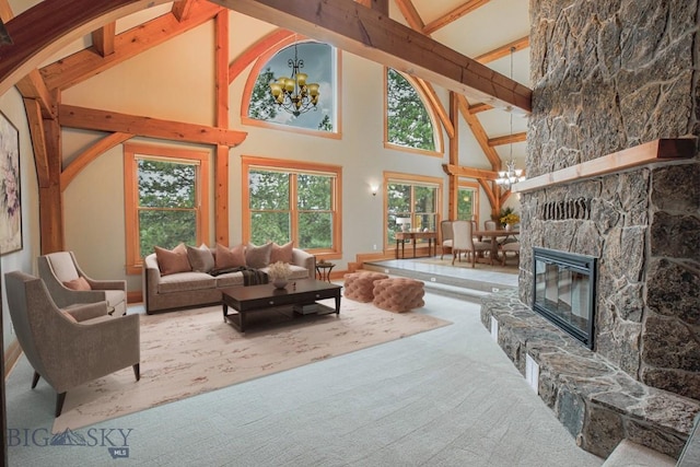 living area featuring beamed ceiling, a fireplace, carpet floors, and a chandelier