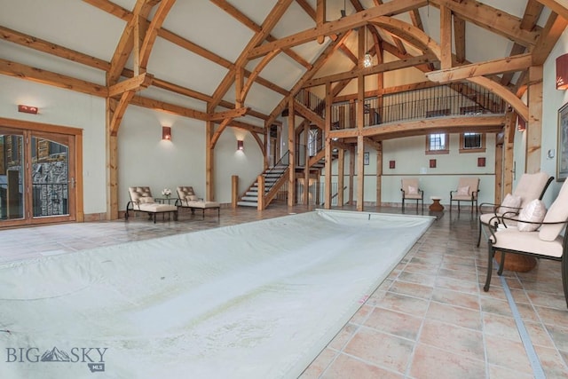 misc room featuring tile patterned floors, beamed ceiling, high vaulted ceiling, and stairs