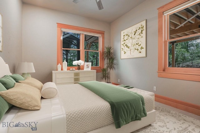 bedroom featuring multiple windows, a ceiling fan, and baseboards