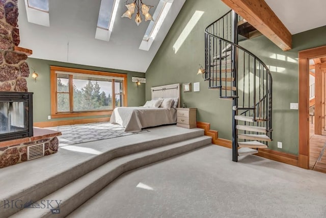 bedroom with beamed ceiling, carpet floors, a stone fireplace, a skylight, and high vaulted ceiling