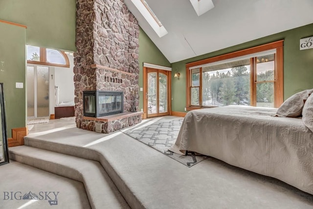 bedroom with access to exterior, a skylight, a fireplace, and high vaulted ceiling